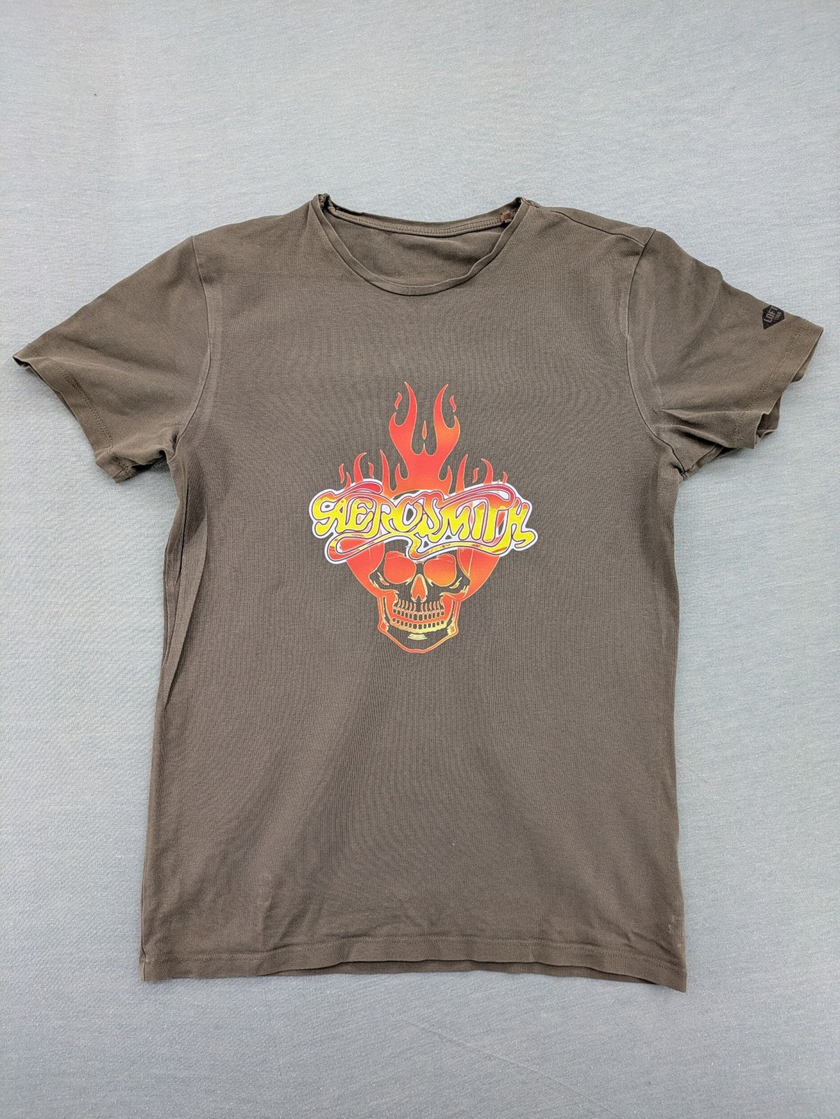 Aerosmith khaki band t-shirt featuring large flaming skull graphic and logo, slim fit.