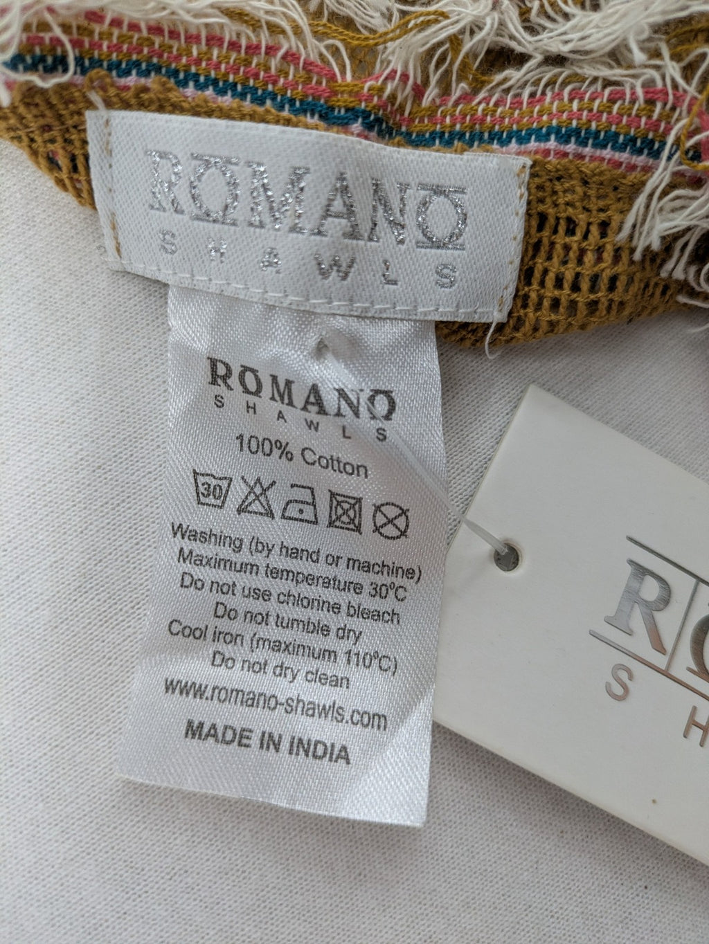 Romano multi scarf ocker with multicolored striped border and fringed edges.
