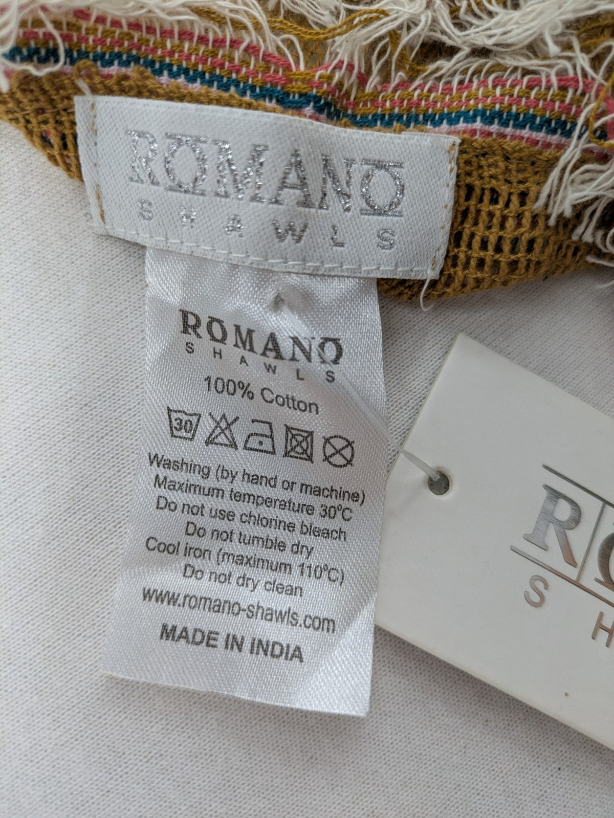 Romano multi scarf ocker with multicolored striped border and fringed edges.