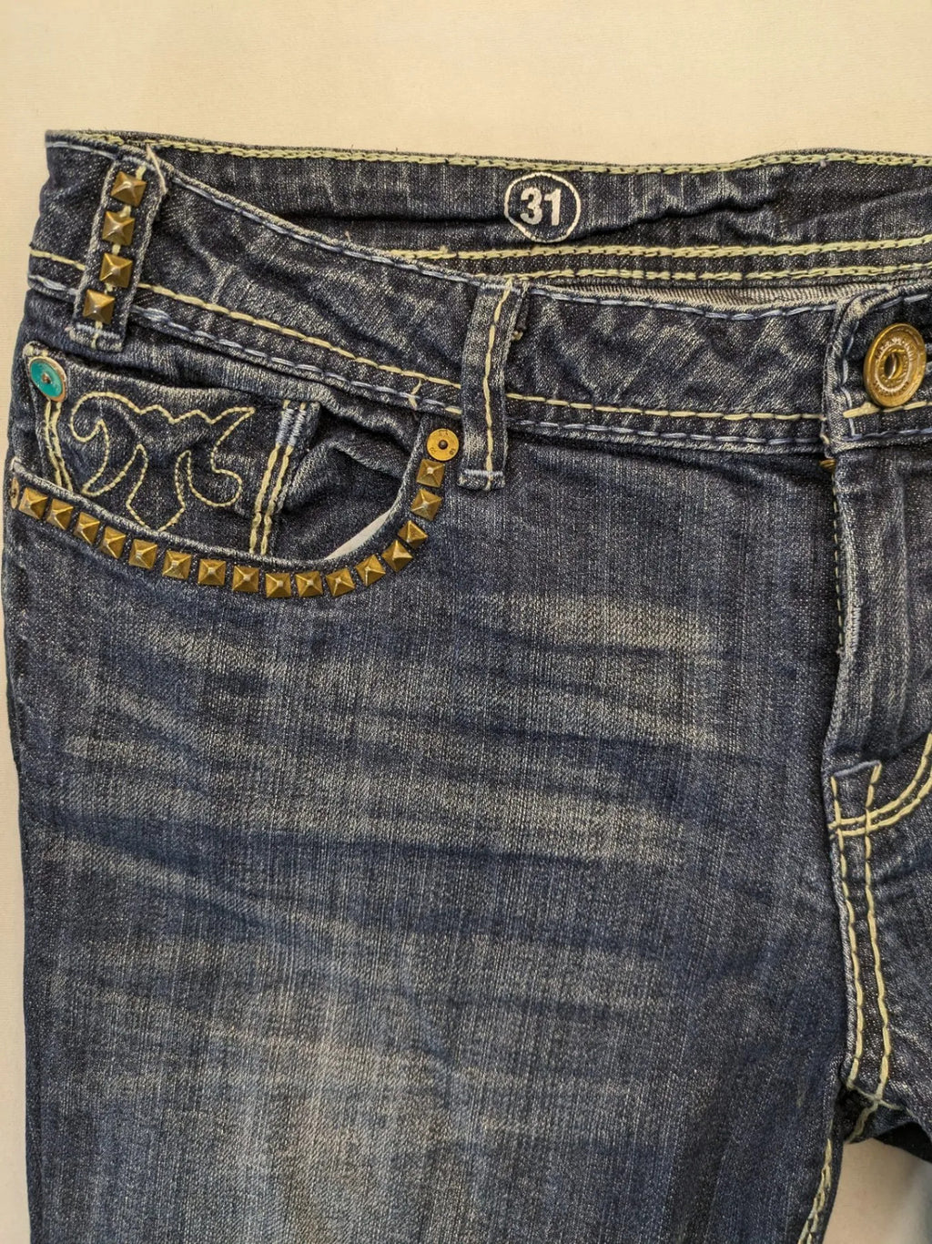 Rhodes blue skinny jeans with decorative studs and intricate embroidery on back pockets.