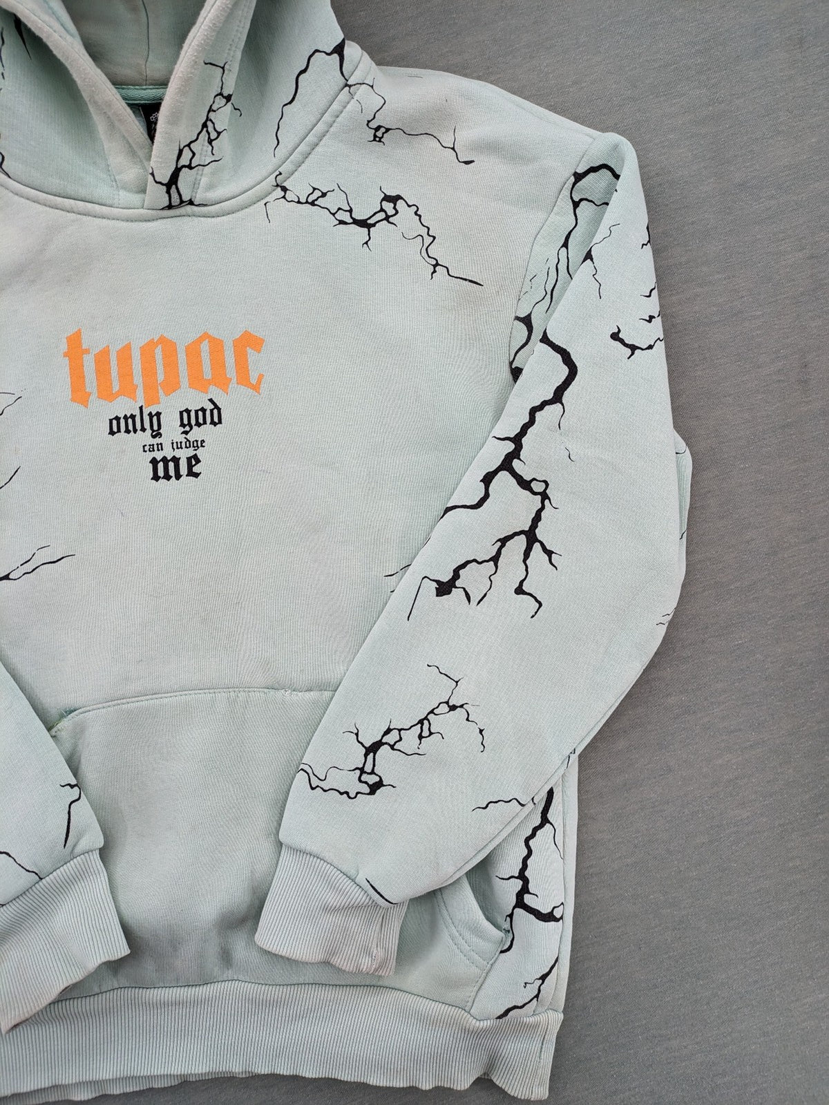 Tupac black and green zip-through hoodie with "Only God Can Judge Me" front print and angel wings graphic.