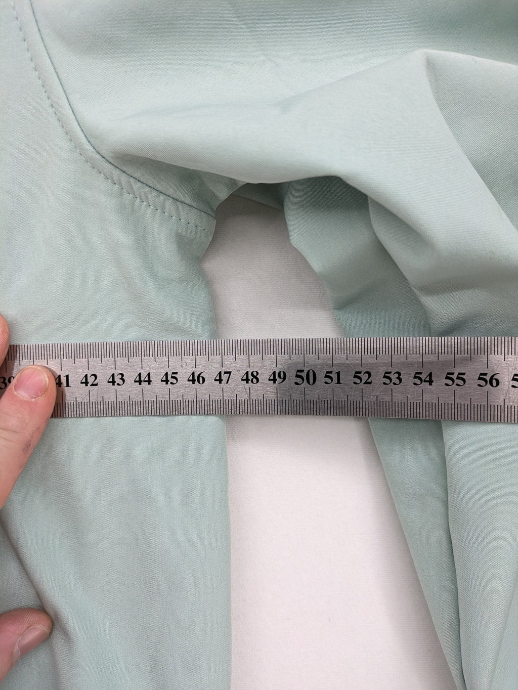 YFK outdoor jacket mint green softshell with dark grey fleece lining and hood.