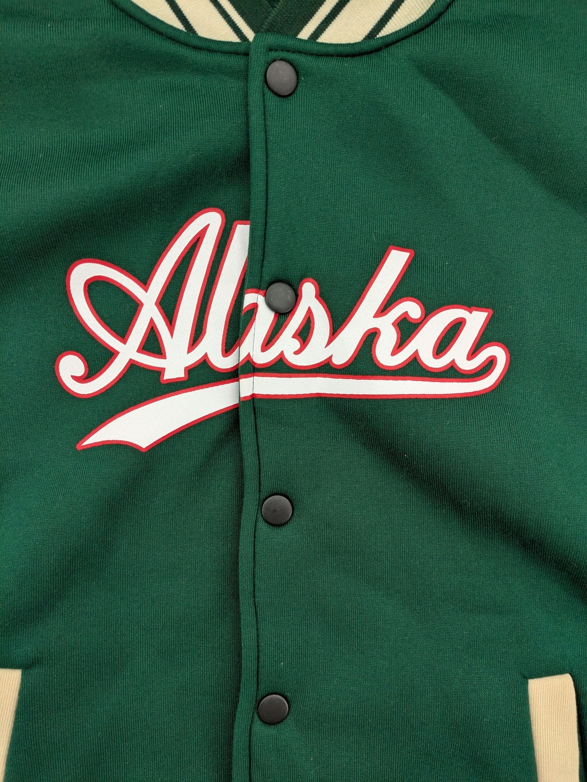 Shein Curve beige bomber jacket with green "Alaska" embroidery and striped ribbed cuffs.