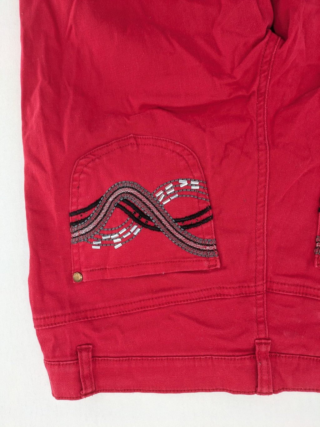 Jet Line red bootcut jeans with embroidered back pockets and pearl embellishments.