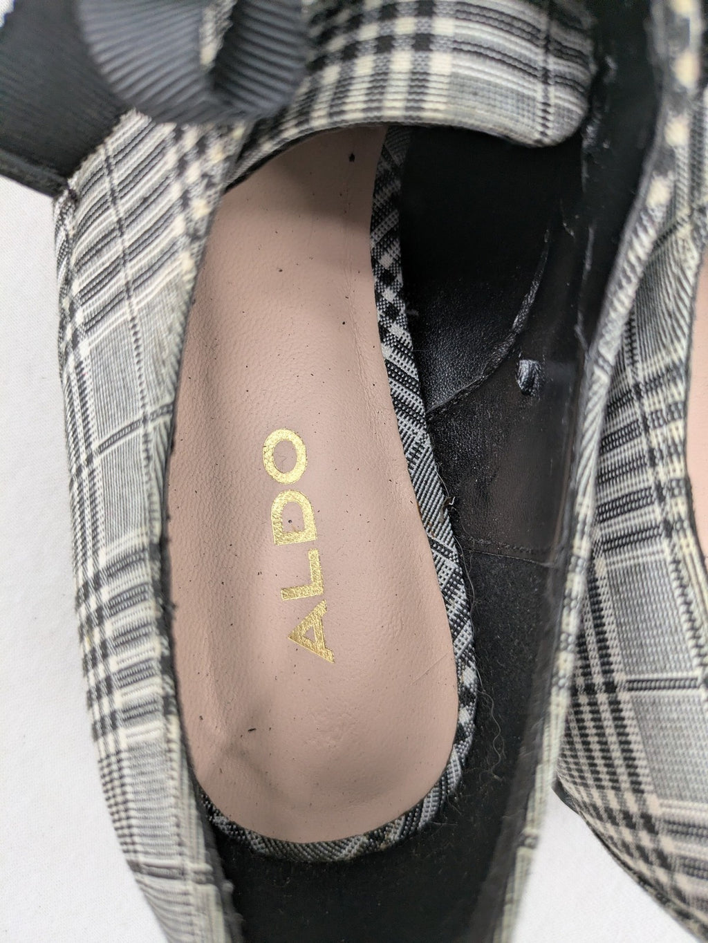 ALDO black and white checkered loafers with decorative bow detail and pointed toe.