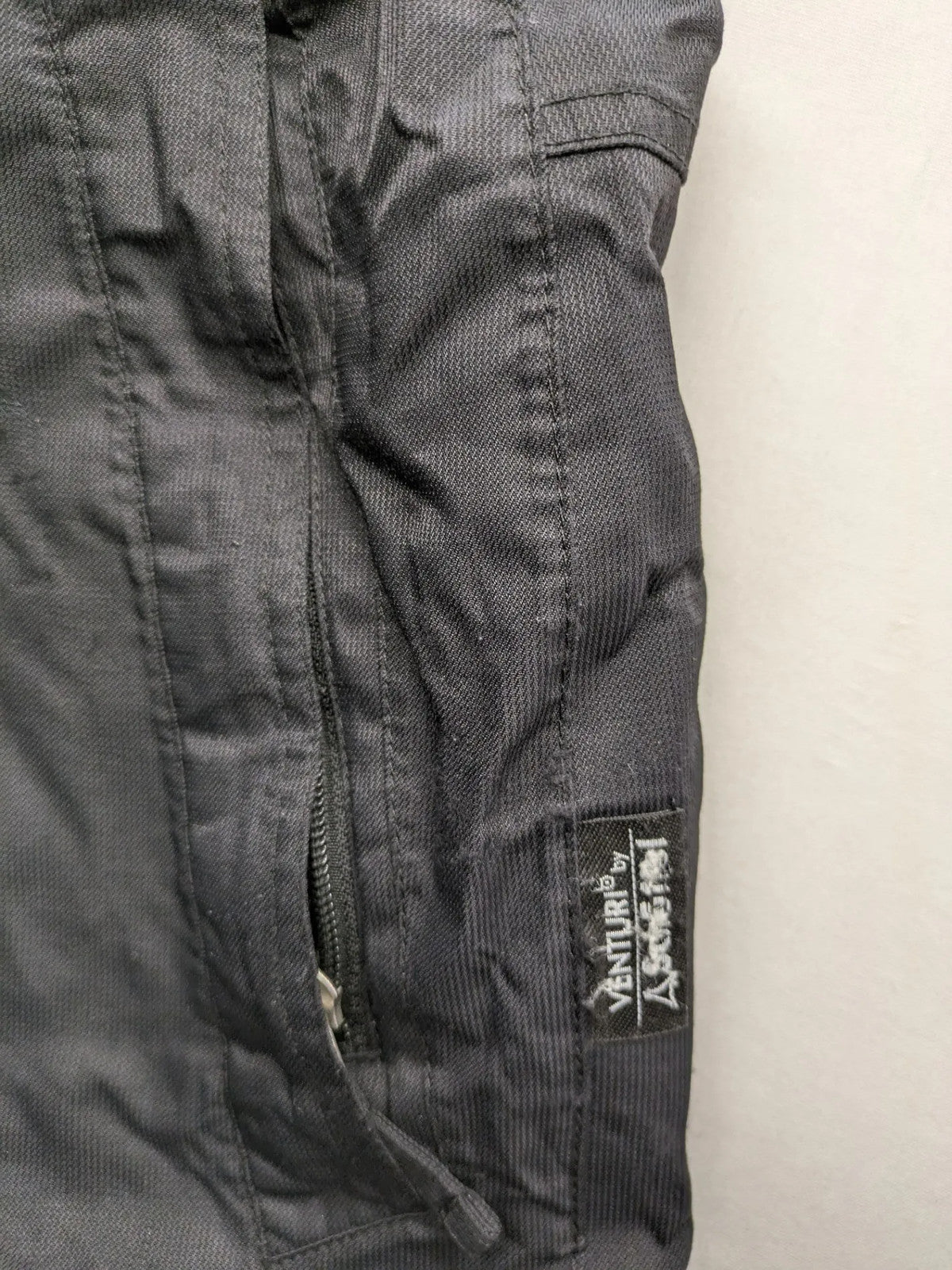 Schoffel black ski pants with adjustable straps, zip pockets, and snow gaiters.
