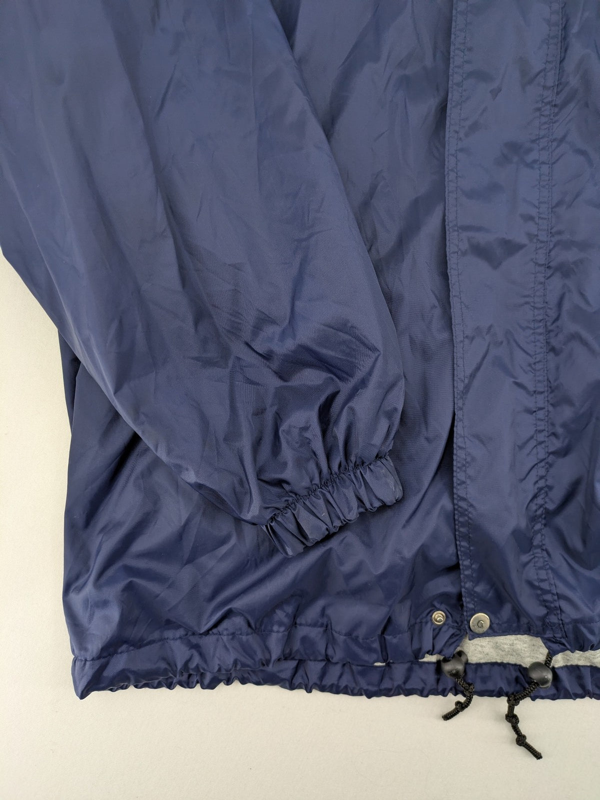 Fila navy windbreaker jacket with large embroidered logo on chest and back.