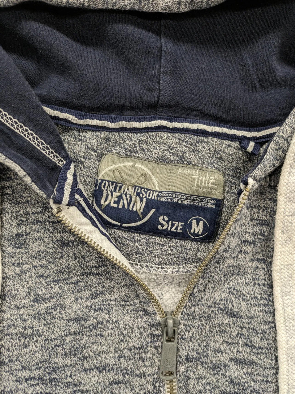 Tom Tompson cream turtle neck jumper with dark blue accents and graphic details on sleeve.