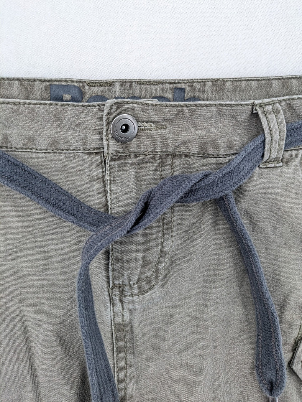 Bench khaki cargo mini skirt with belt, multiple pockets, and durable cotton material.