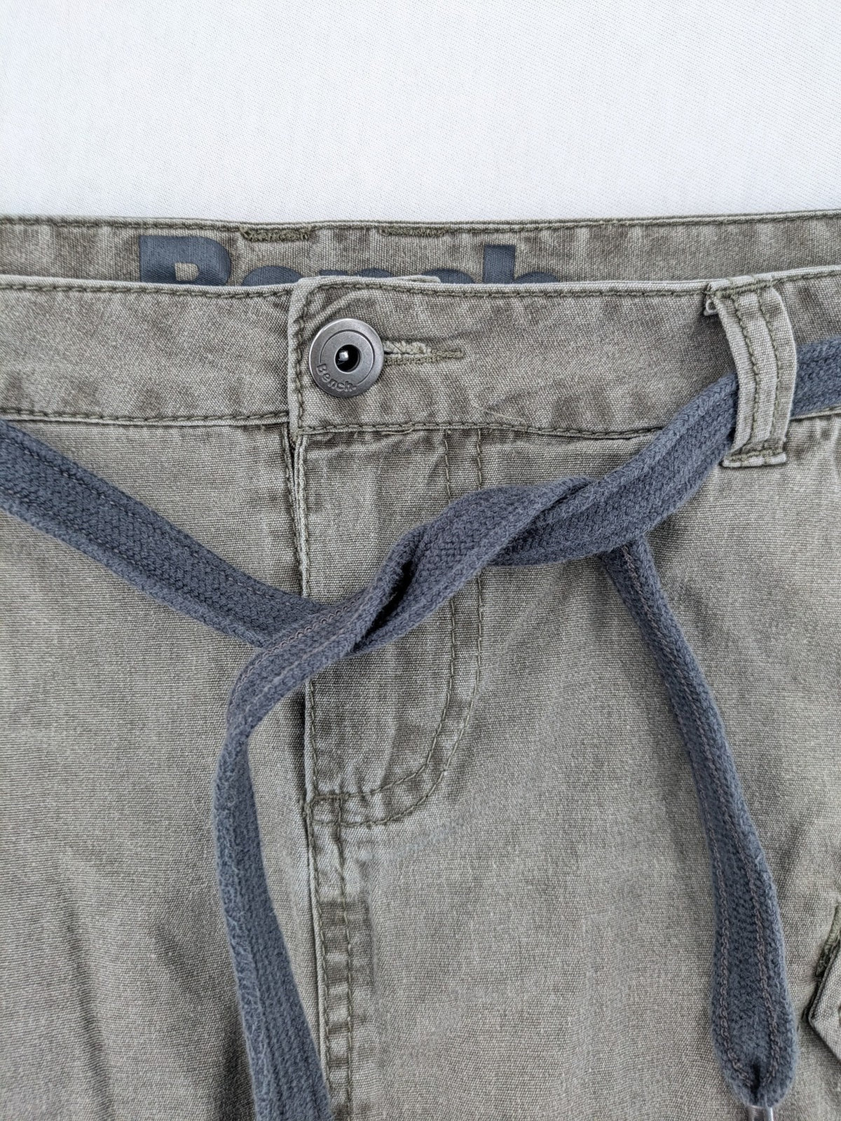 Bench khaki cargo mini skirt with belt, multiple pockets, and durable cotton material.