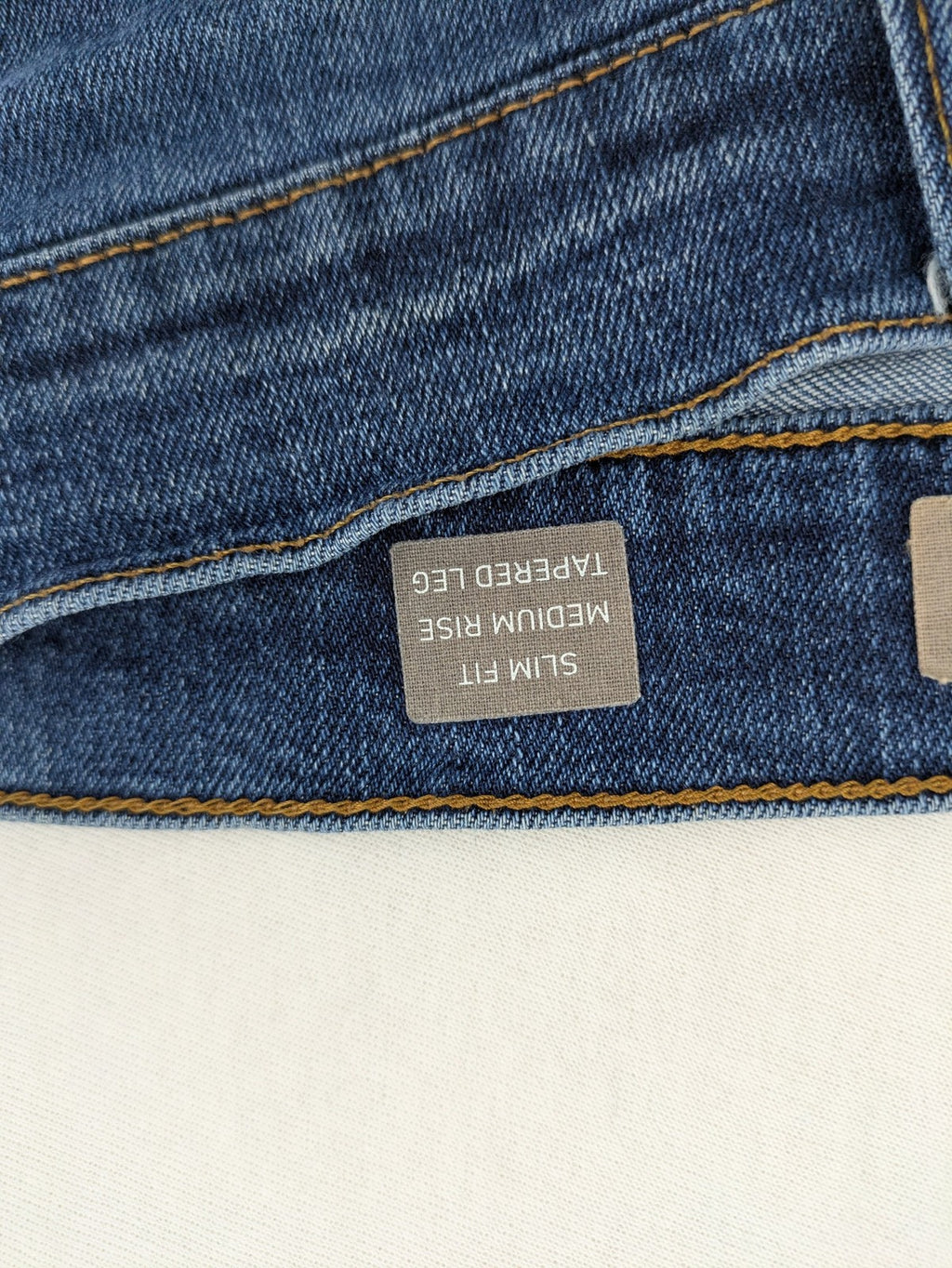 Mustang blue tapered jeans with slim fit, medium rise, and classic denim texture.