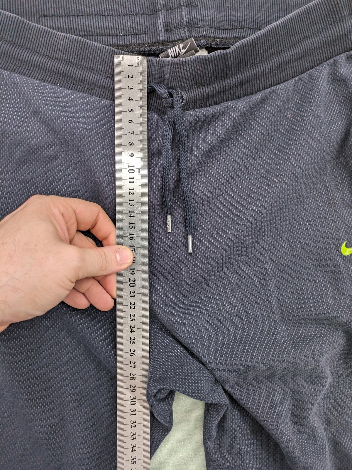 Nike F.C. grey jogger pants with elastic waistband, side pockets, and embroidered Swoosh logo.