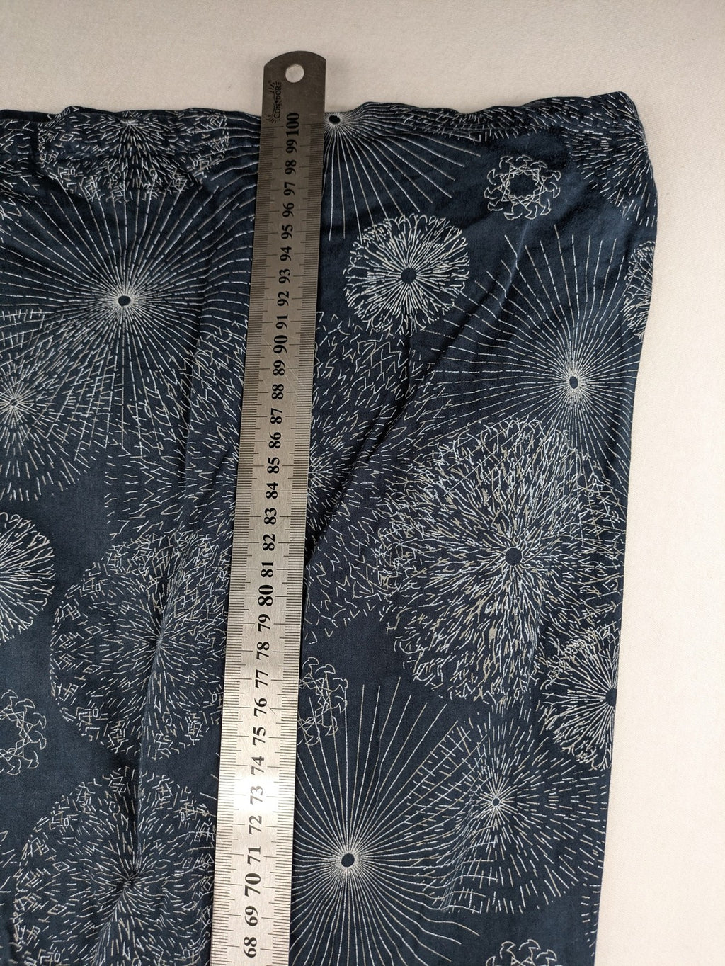 Muster navy dress with white abstract dandelion print, V-neck and collar details.