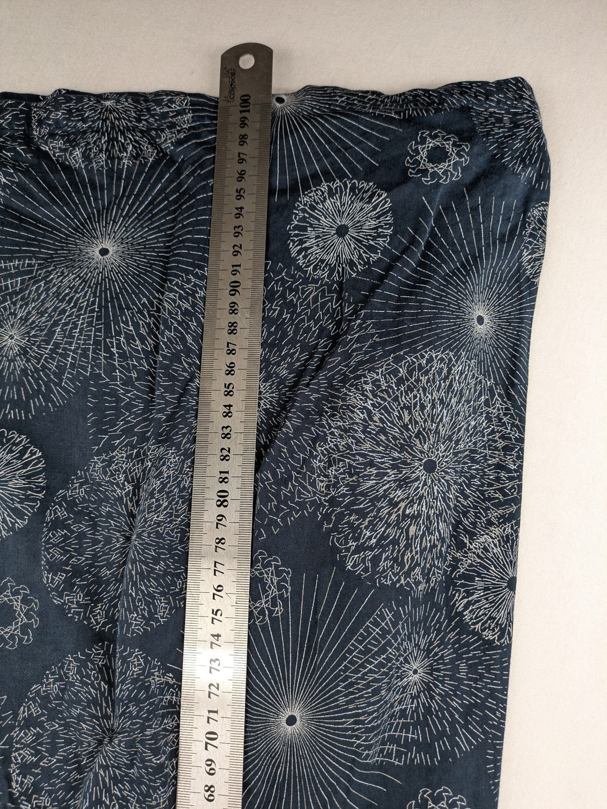 Muster navy dress with white abstract dandelion print, V-neck and collar details.