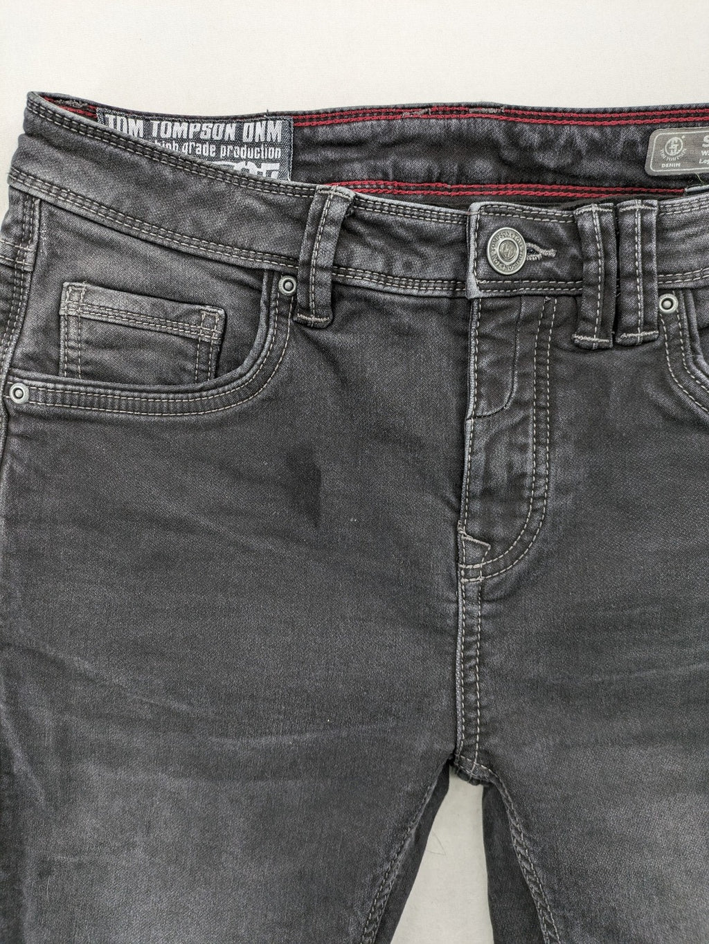 Tom Tompson grey slim tapered jeans with washed denim finish and subtle branding.