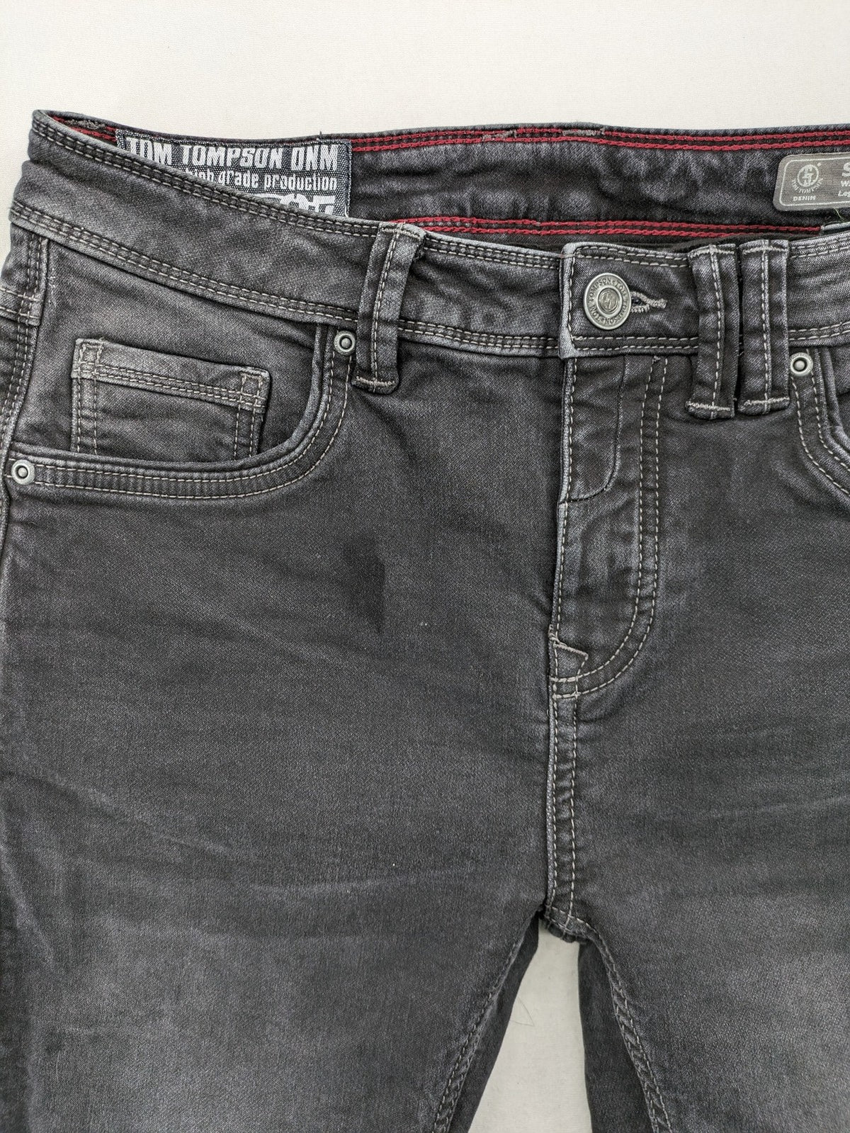 Tom Tompson grey slim tapered jeans with washed denim finish and subtle branding.