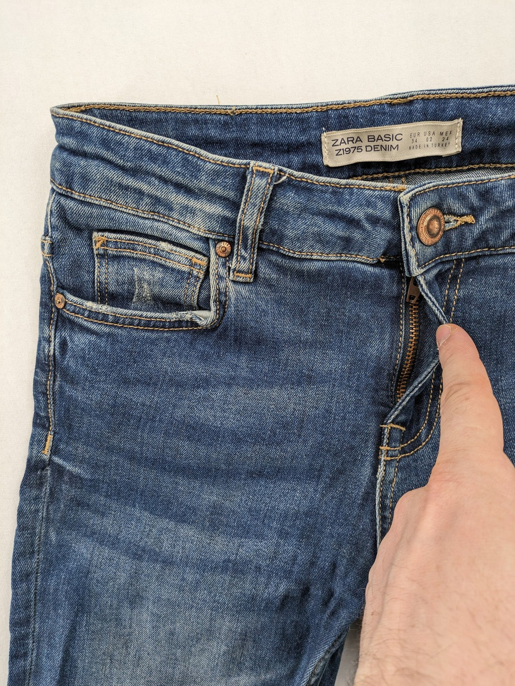 Zara Basic blue skinny jeans with destroyed knee details and frayed hem.