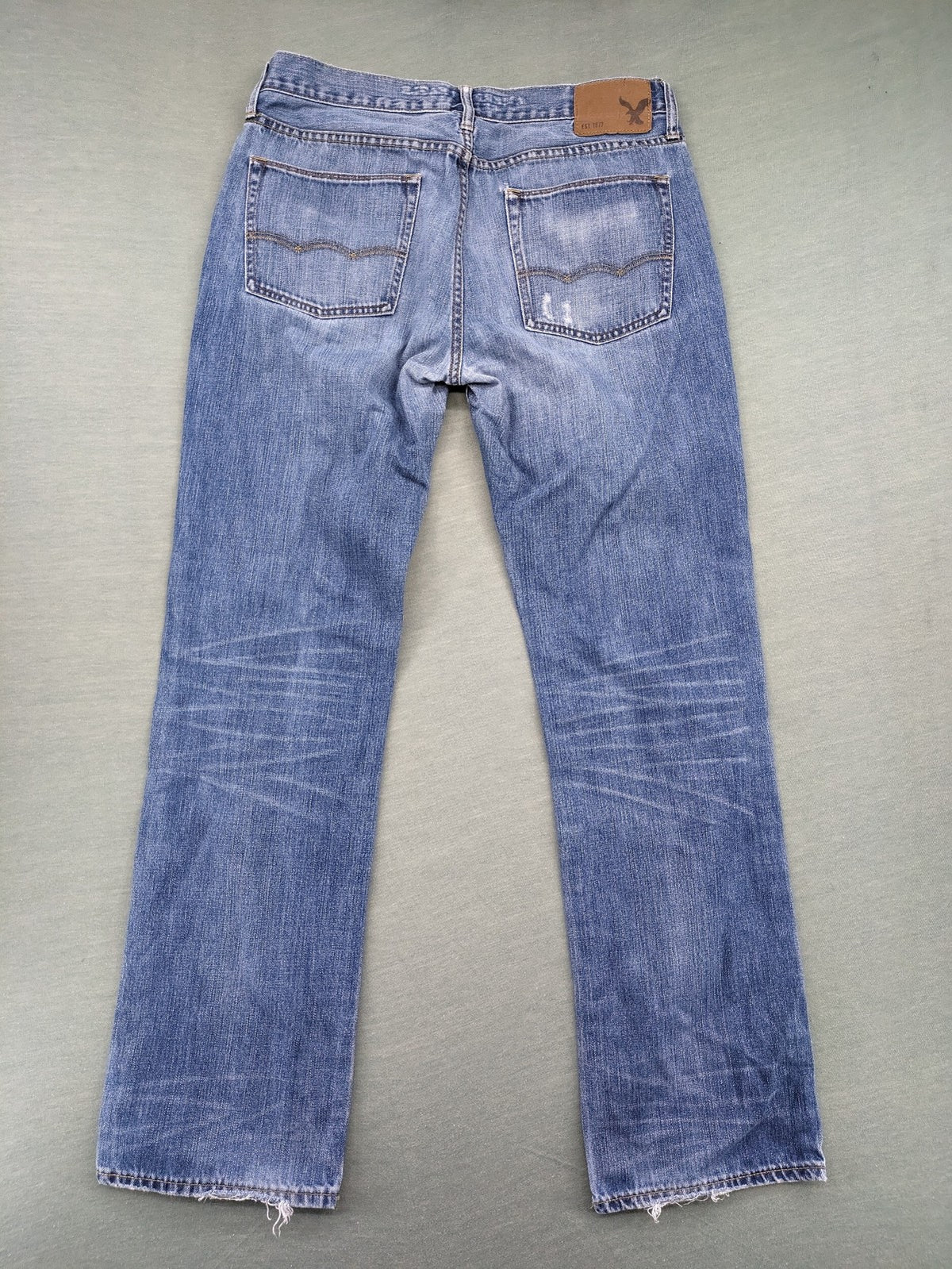 American Eagle Outfitters blue straight jeans with distressed detailing and classic five-pocket design.