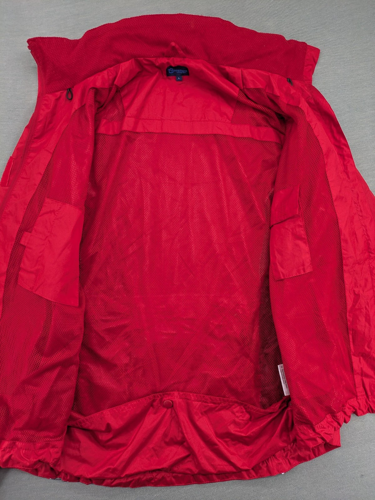 Movement Session grey and red windbreaker jacket with colorblock pattern and full zip.