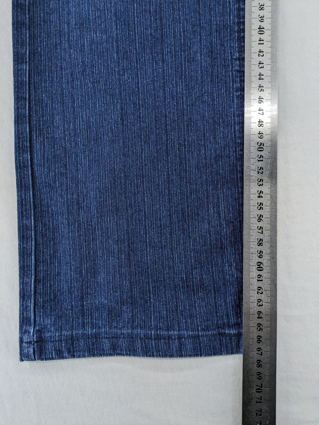 Outfit blue straight jeans with elastic waistband and embroidered crown-wing emblem on pockets.