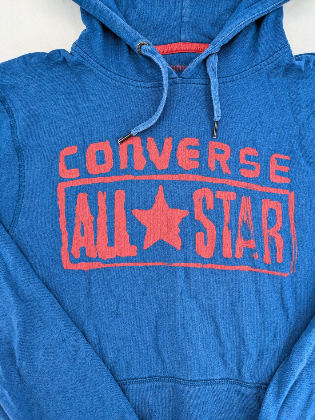 Converse All Star blue zip-through hoodie with red graphic logo and kangaroo pocket.