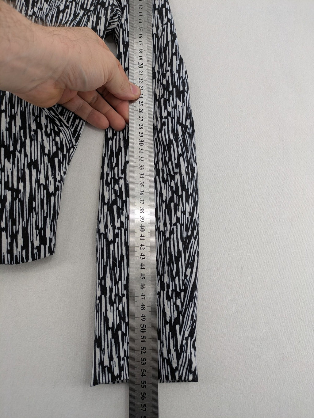 H&M Divided black and white patterned blazer with open front and two front pockets.