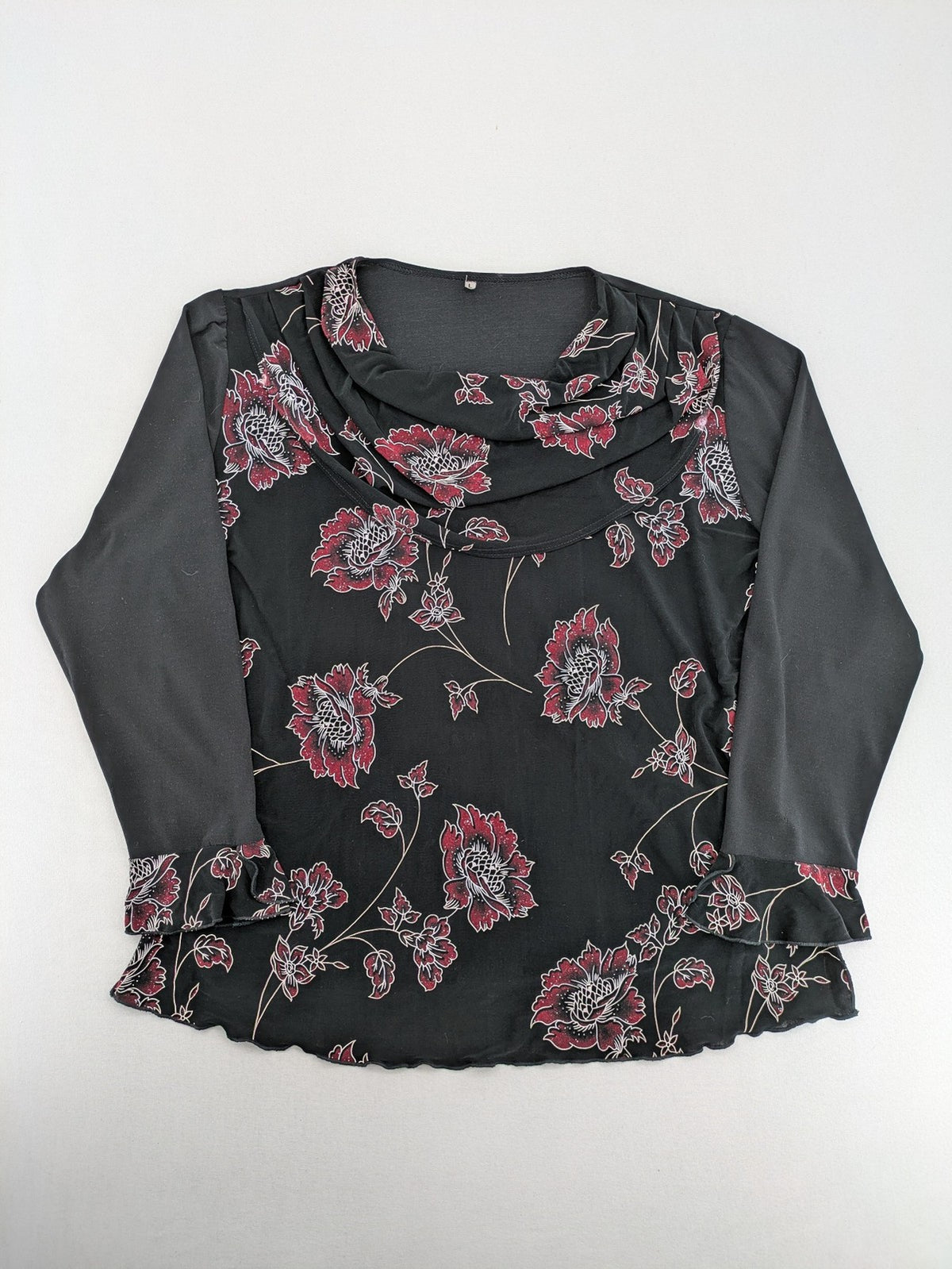 Damen black top with burgundy and white floral print, waterfall collar, and ruffled sleeves.