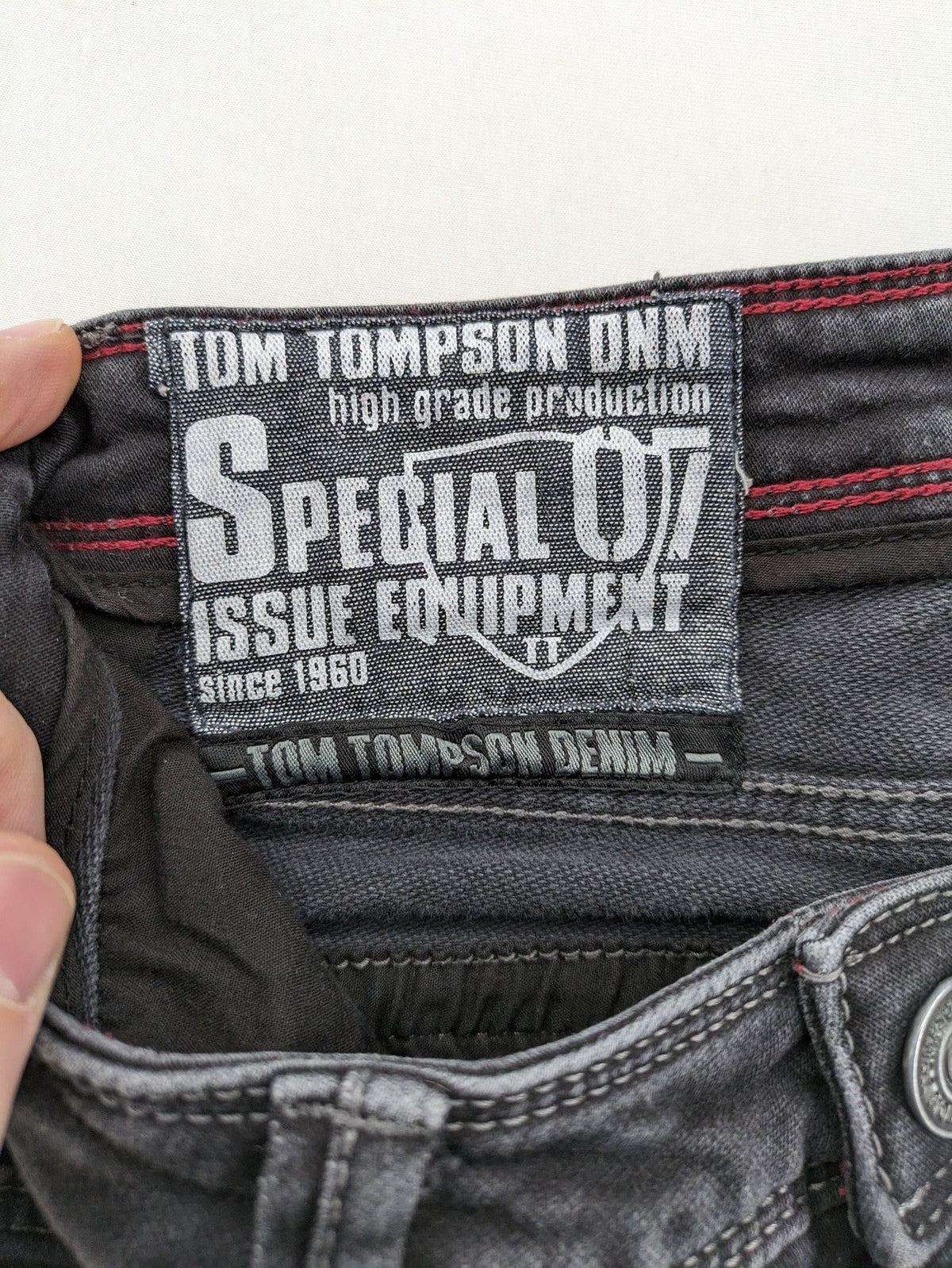 Tom Tompson grey slim tapered jeans with washed denim finish and subtle branding.