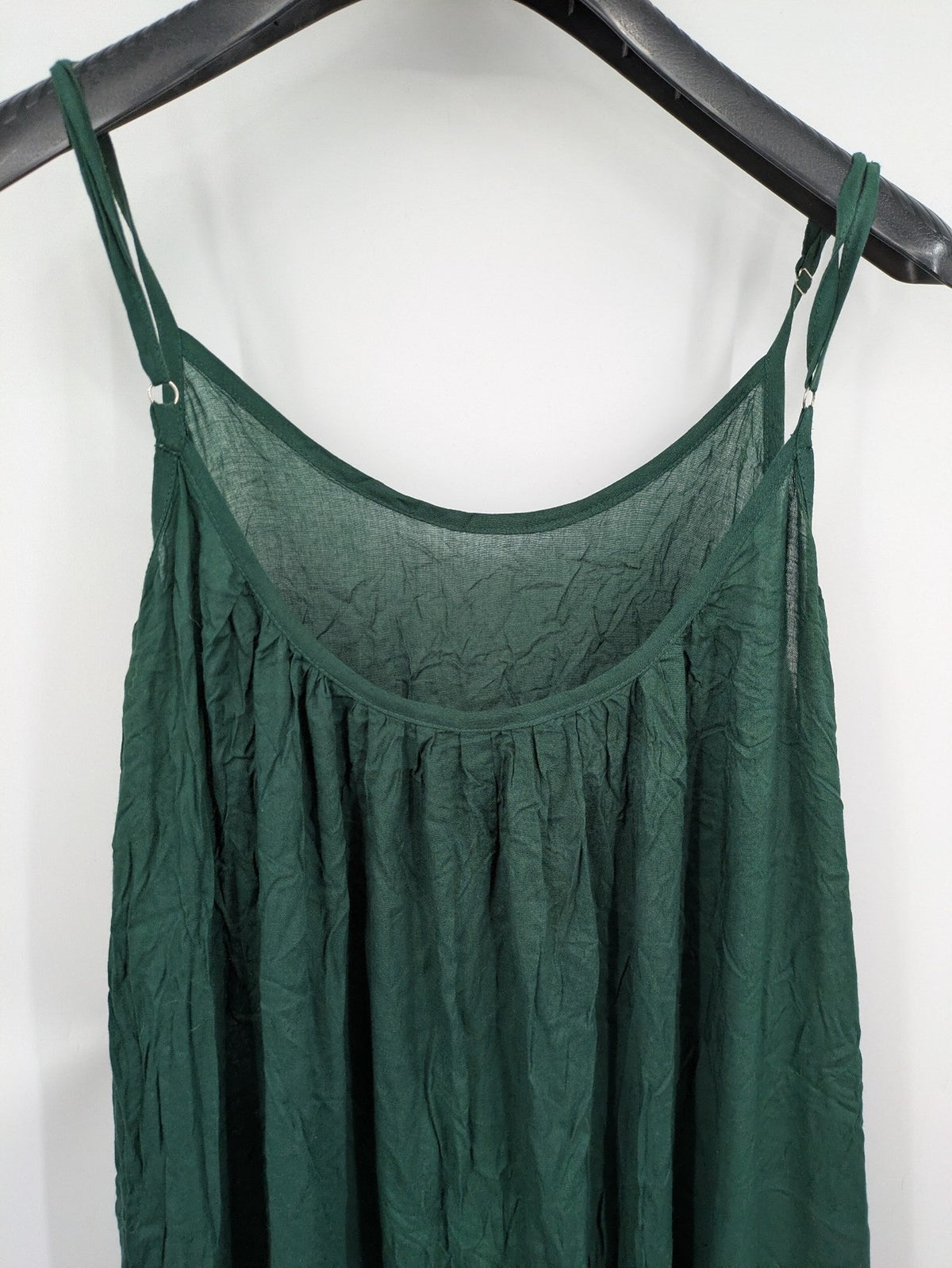 Boho green maxi dress with floral embroidery along tiered hem and adjustable spaghetti straps.