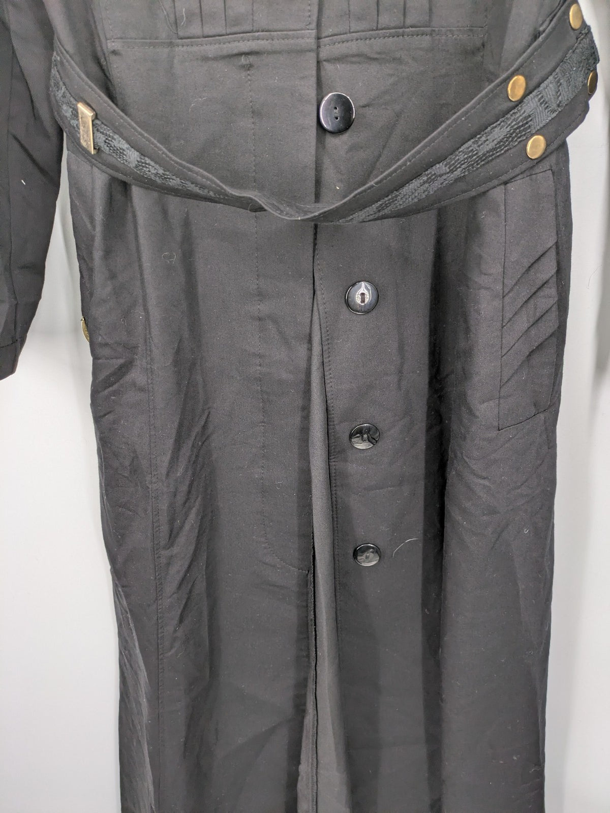 Alvina black trench coat with lace collar and gold buttons, belted waist design.