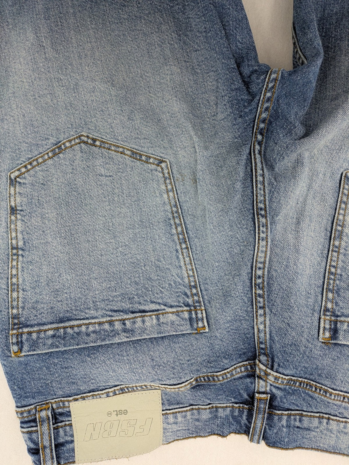 FSBN blue straight jeans with ripped distressed knees and classic button fly.