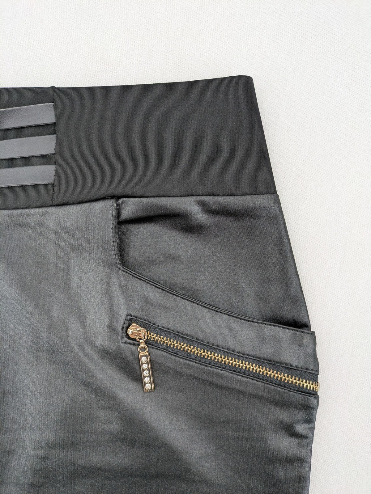 Romatie black mini bodycon skirt satin finish high waist with gold zippers and buckles.