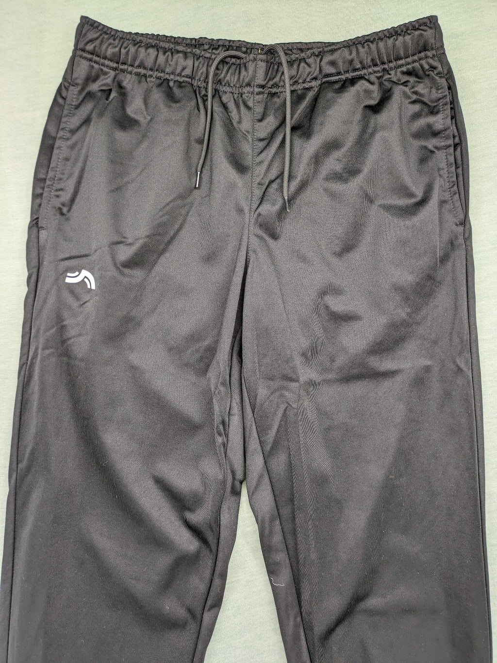 Crivit black weighted training pants with elastic waistband, side pockets, and zippered cuffs.