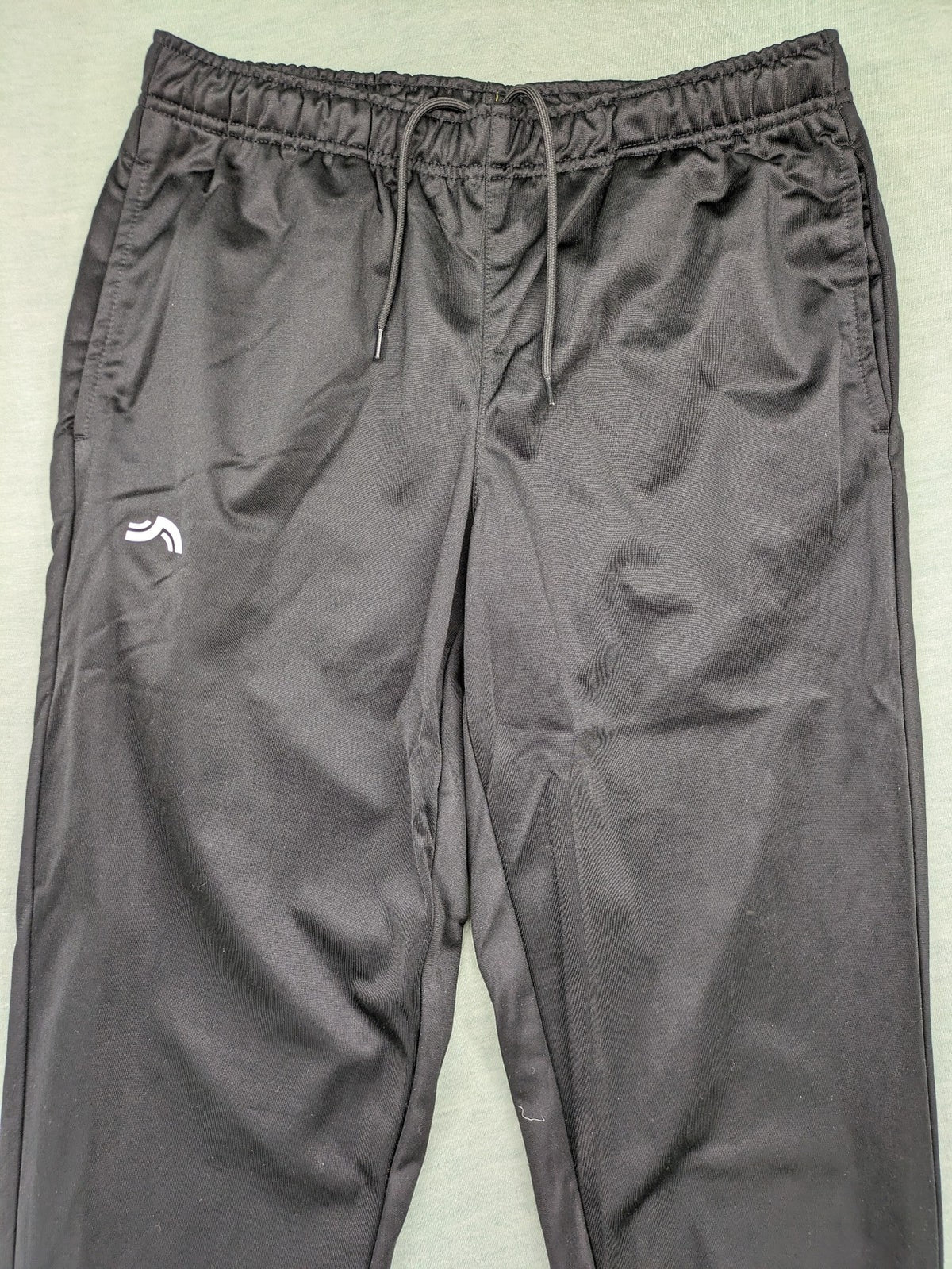 Crivit black weighted training pants with elastic waistband, side pockets, and zippered cuffs.