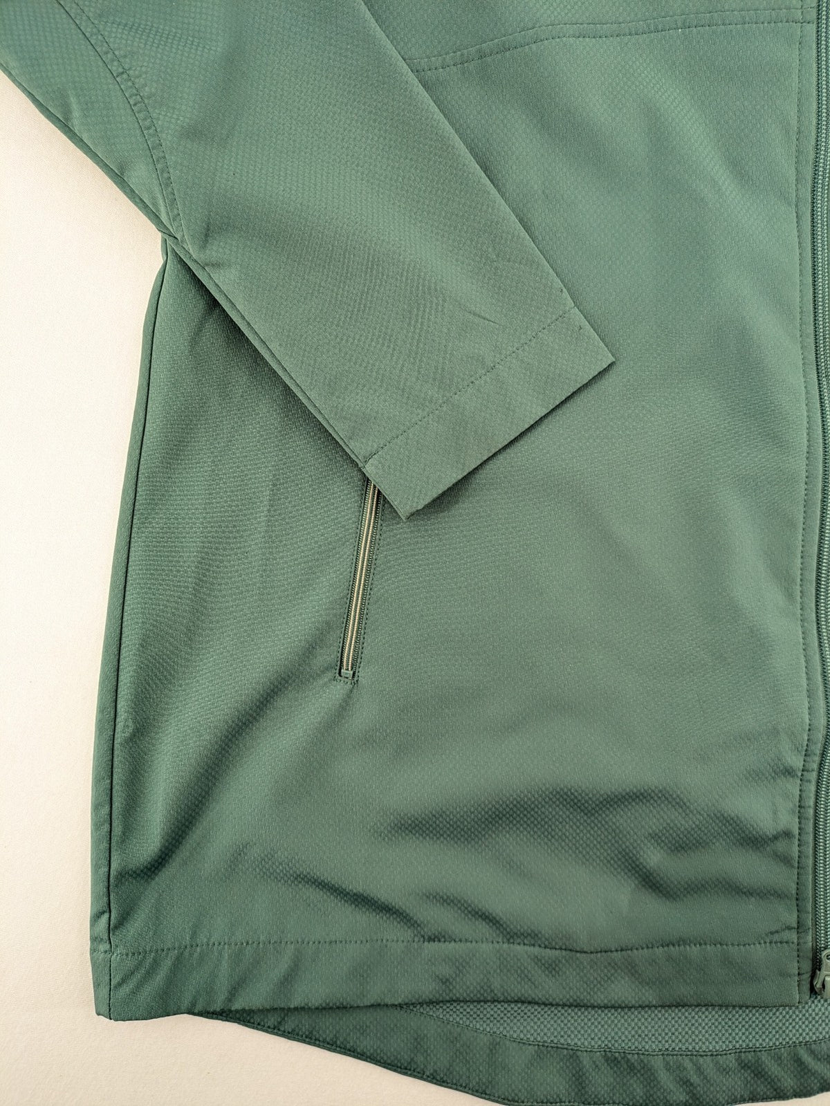 Frilufts green softshell jacket with hood, longline design, durable zipper, practical zip pockets.