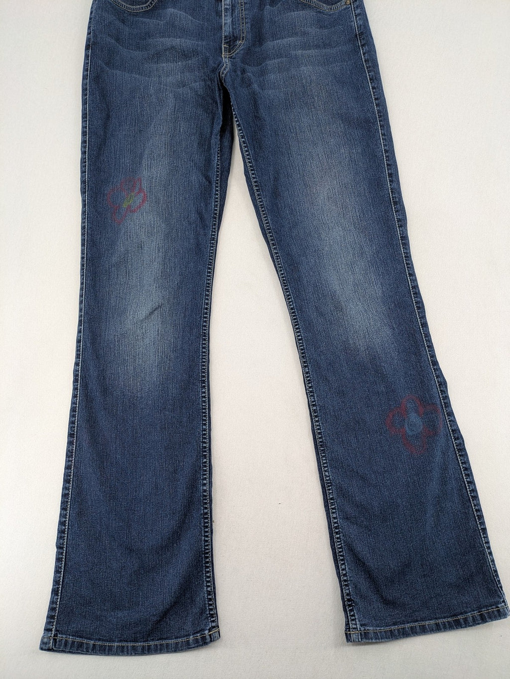 Mustang blue bootcut jeans with custom painted floral designs on both legs.