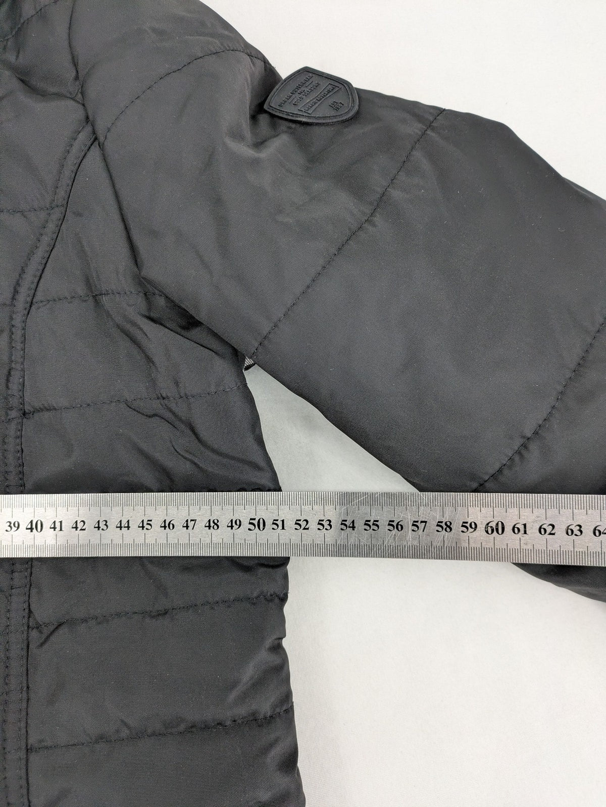 Vero Moda black quilted jacket with hood, reflective stripes, nylon material.