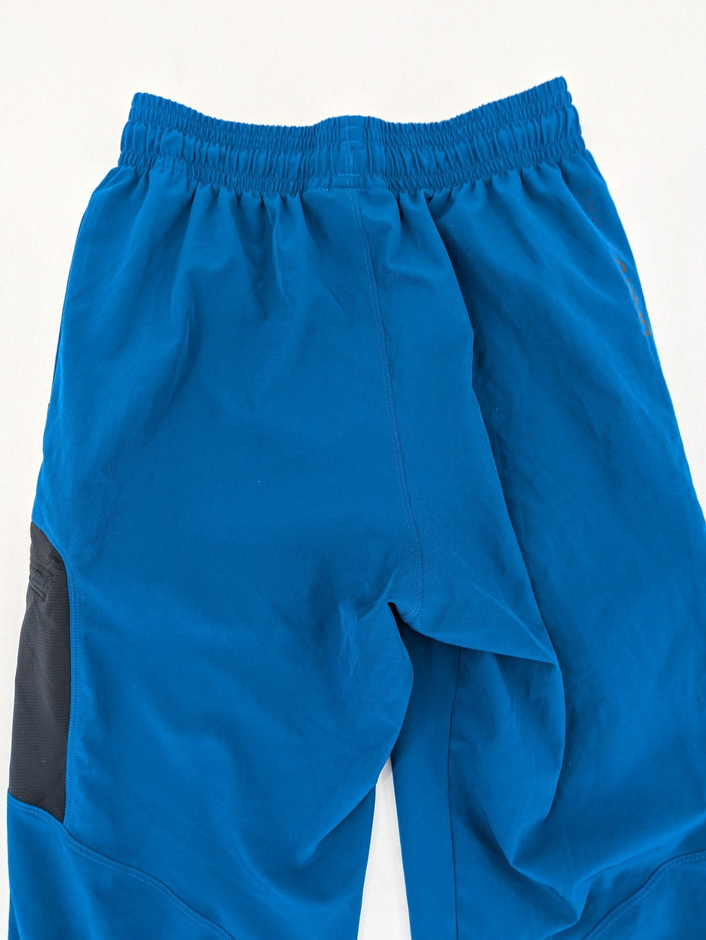 Under Armour blue HeatGear joggers with black accents and zippered cargo pockets.