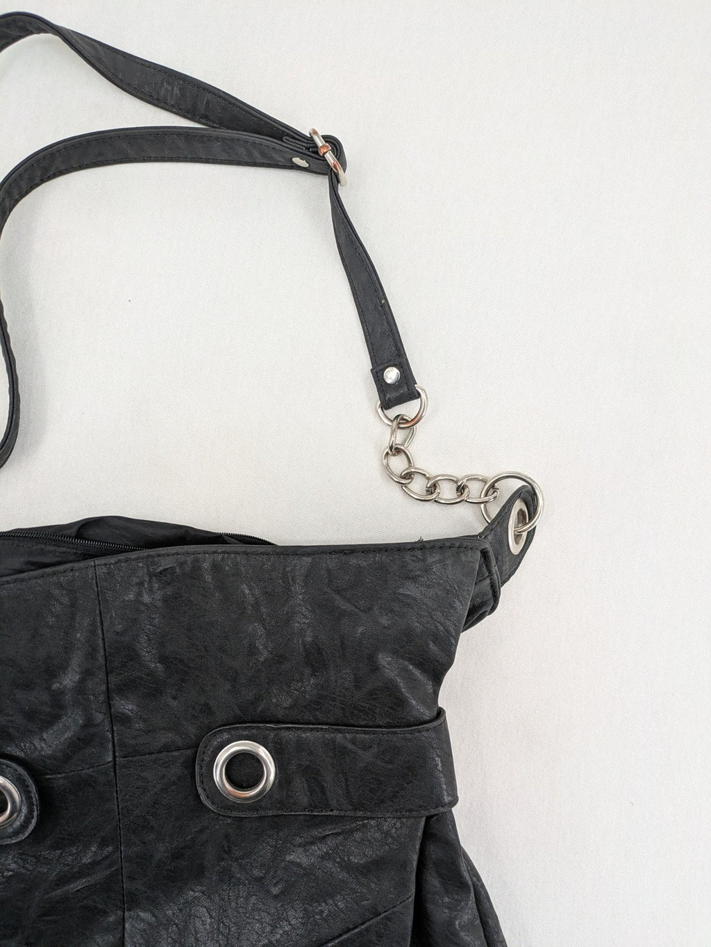 New Yorker black hobo handbag with silver chain details and large eyelets.