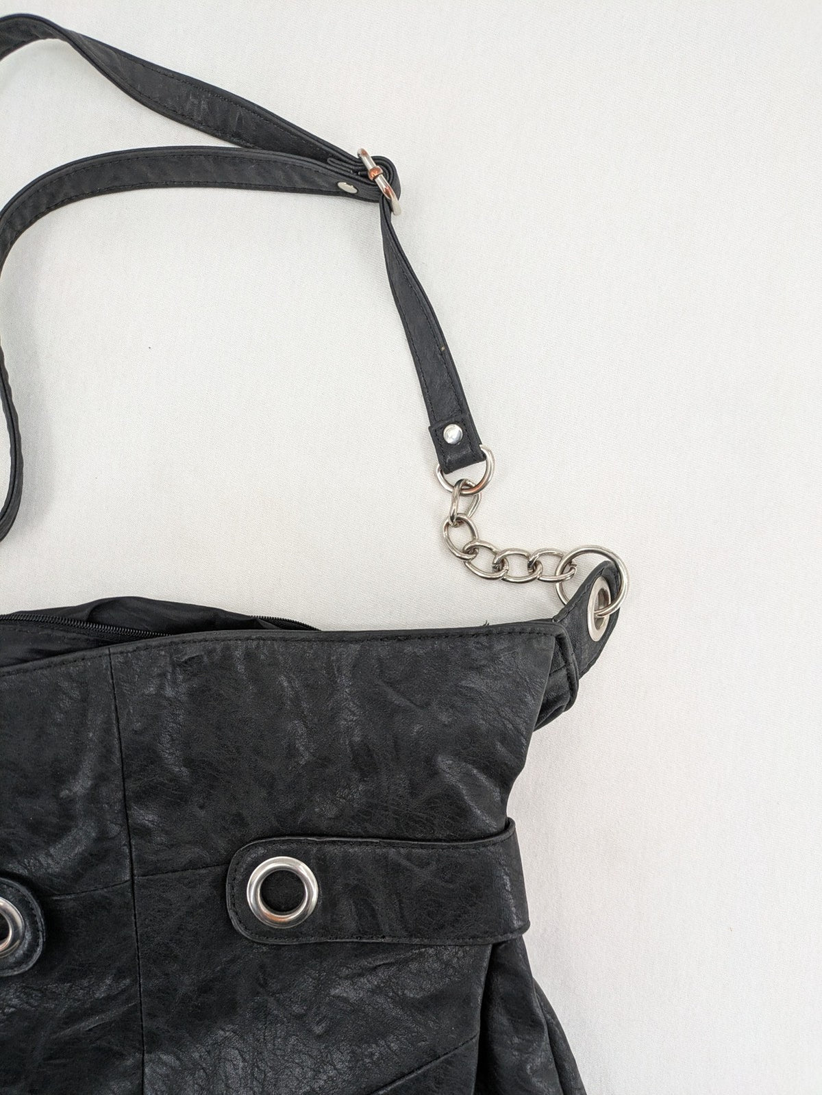 New Yorker black hobo handbag with silver chain details and large eyelets.