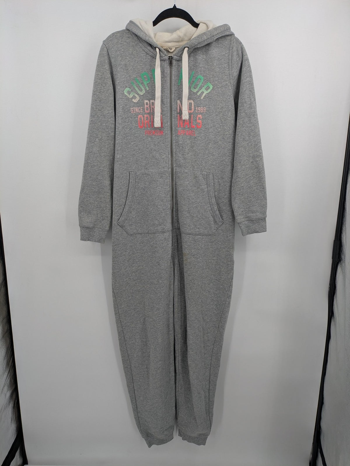 ESMARA cream jumpsuit with hood, graphic print, and front zipper, soft material.