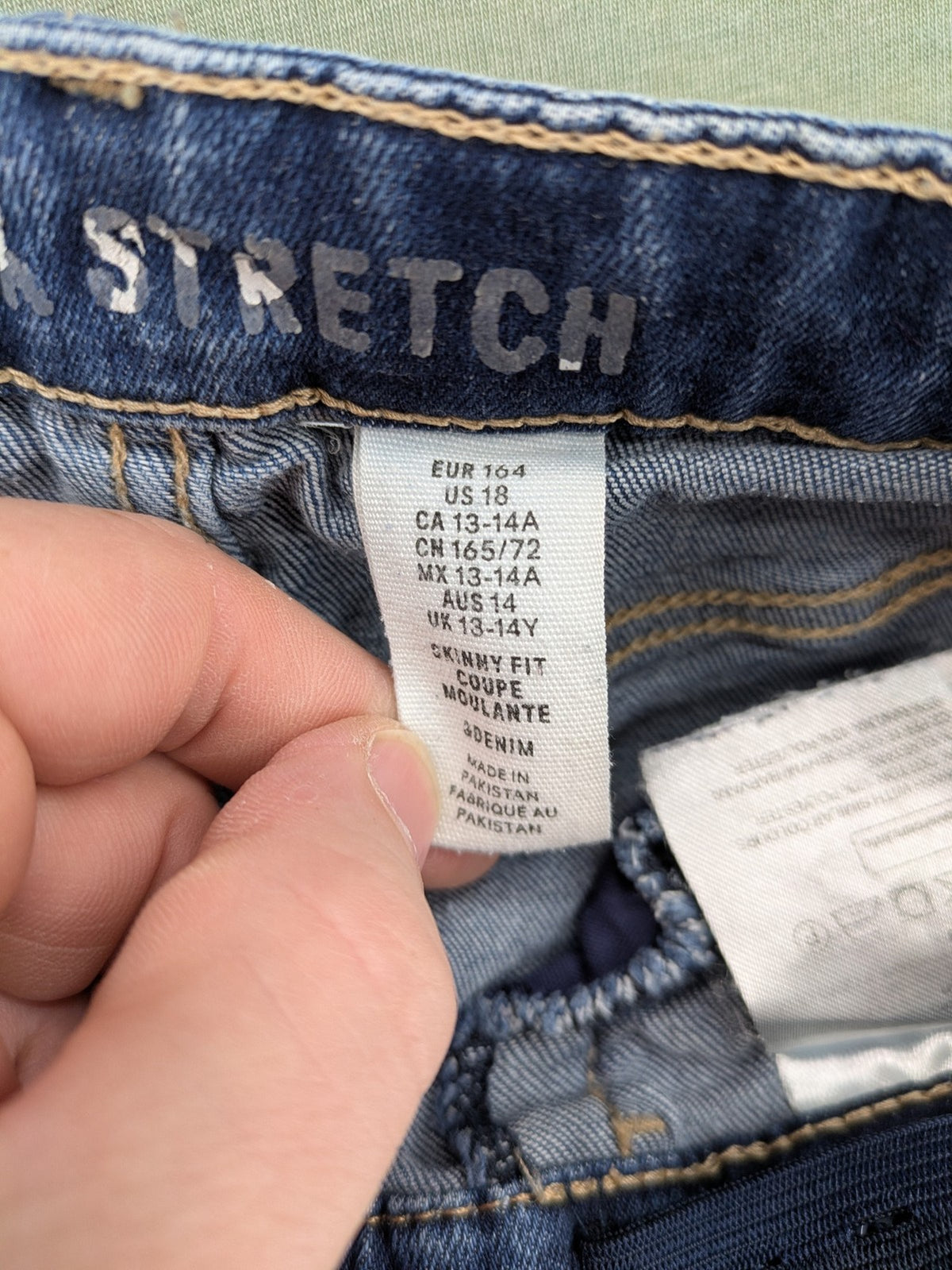 H&M blue skinny jeans with distressed knee details and classic 5-pocket design.