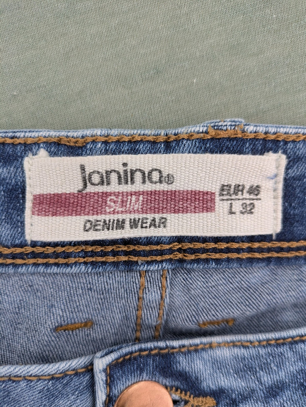 Janina blue slim fit jeans with acid wash, destroyed details, and button fly.