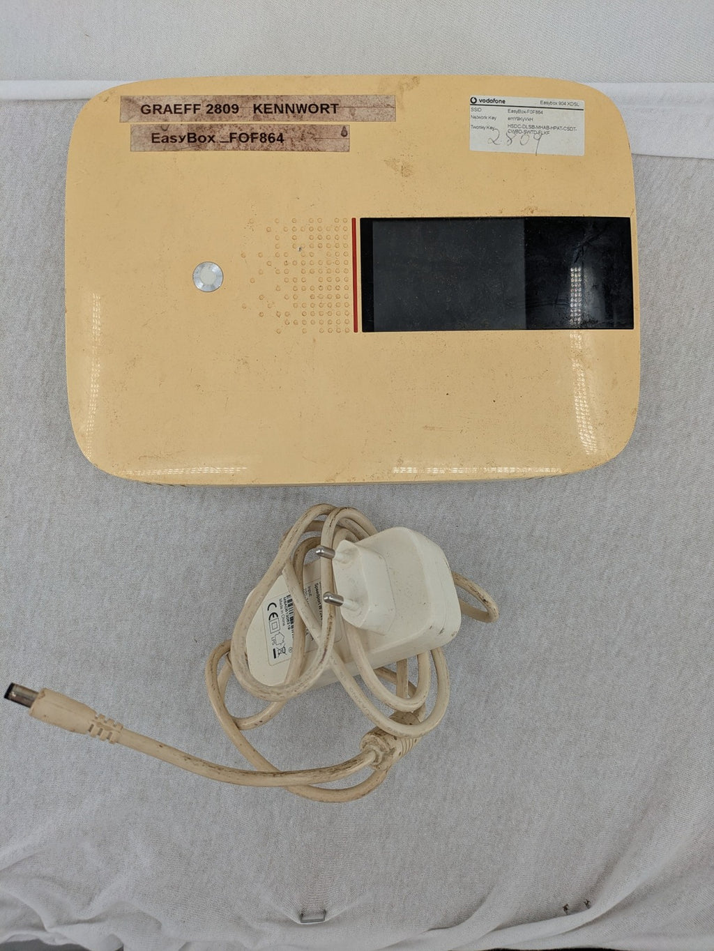 Vodafone wireless router beige and black with multiple LAN ports and USB connection.