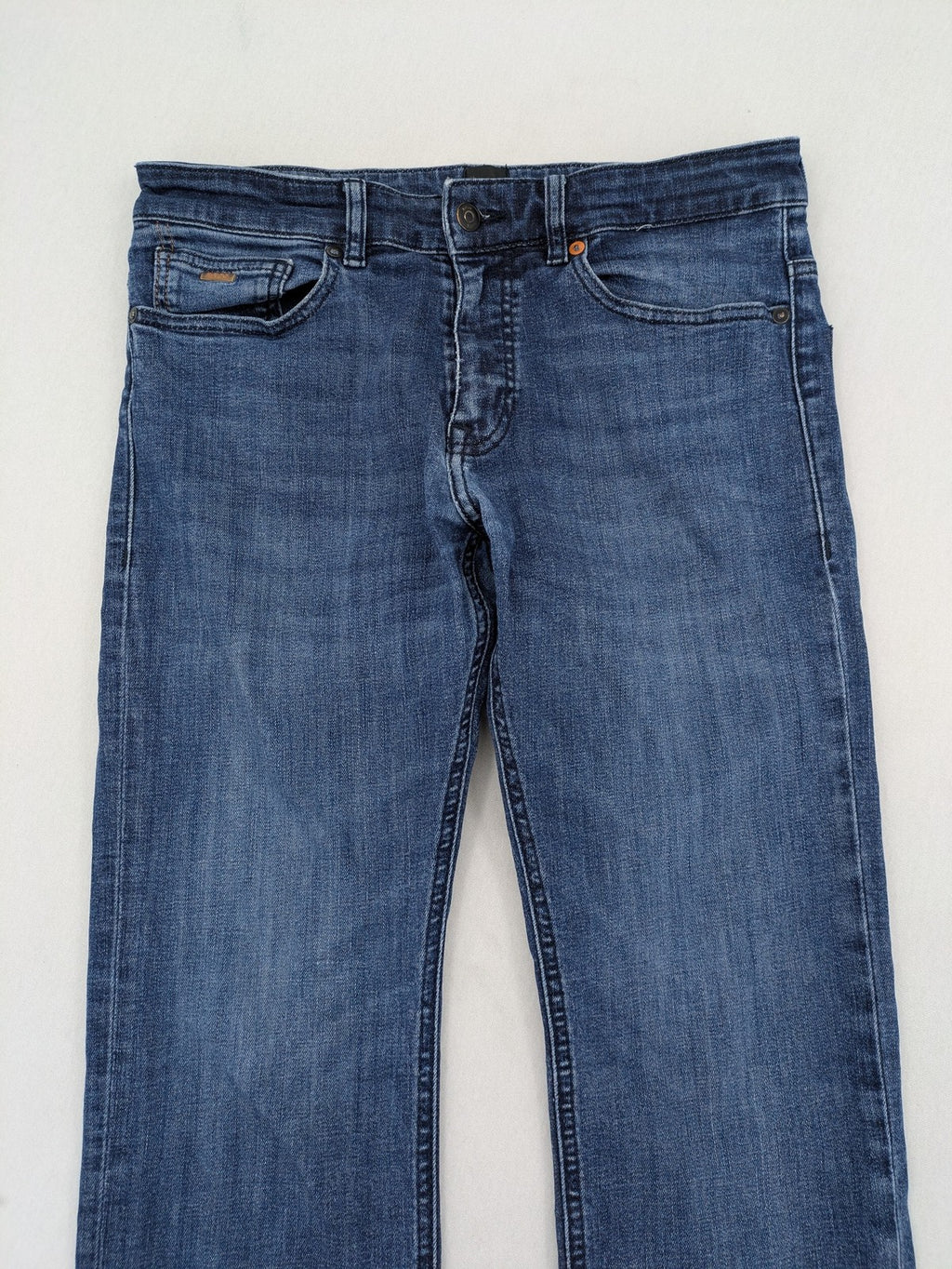 BOSS blue slim fit jeans with logo, five-pocket design, and button fly.