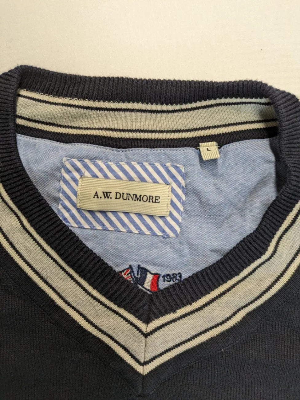 dunmore turtle neck jumper dark blue with striped trims and embroidered crest logo