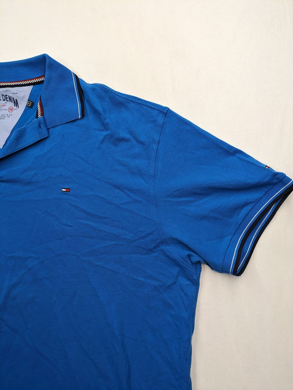 Tommy Hilfiger blue polo shirt with white stripes and embroidered logo on chest.