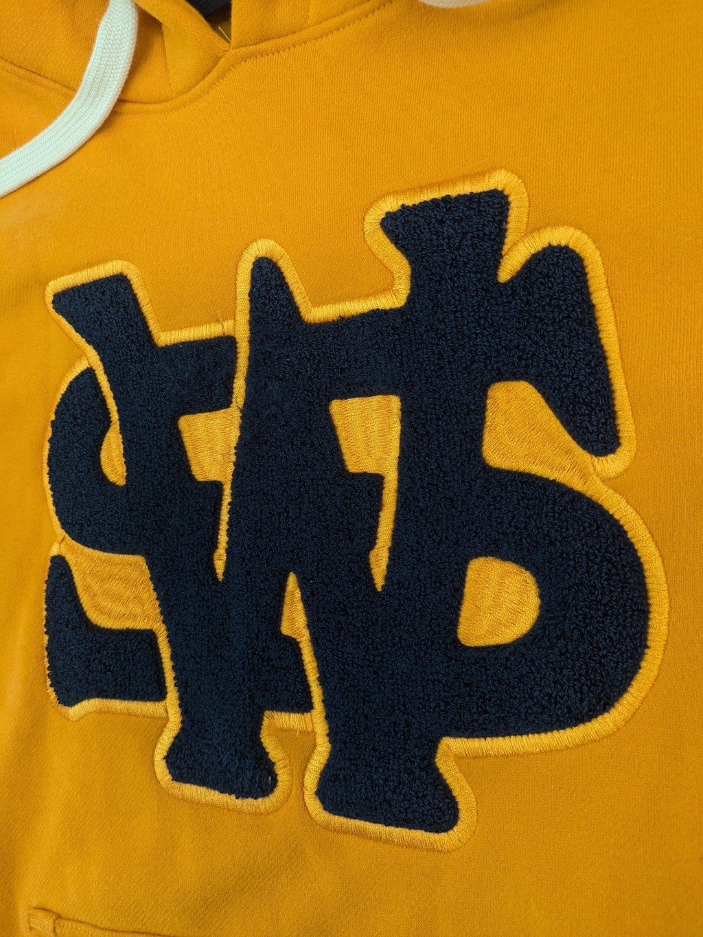 Superdry orange turtle neck jumper with textured logo patch and number 7 detail.