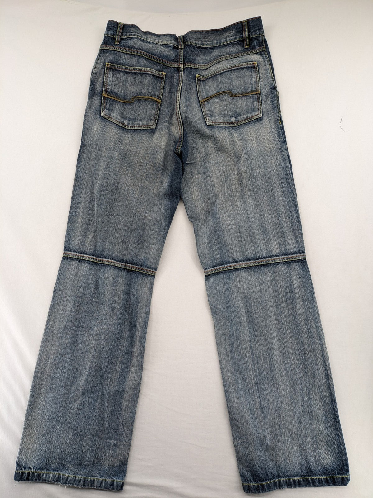 Identic orange straight jeans with paneled design and contrasting yellow stitching.
