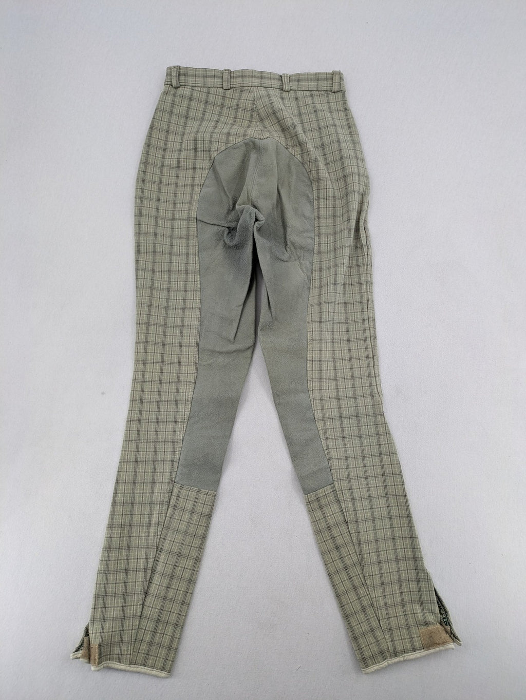 Jodhpur beige and grey riding pants with green check pattern and knee patches.